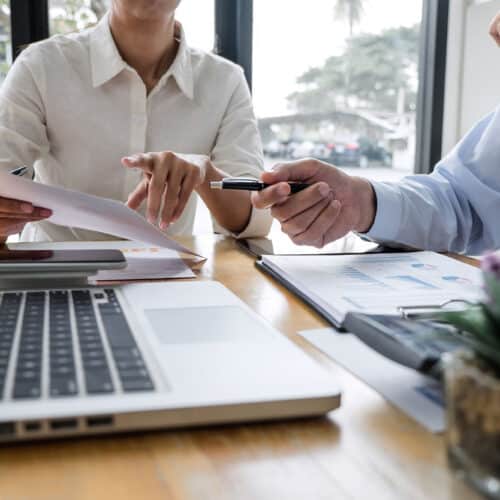 Business professional reviewing loan management software dashboard on a laptop.